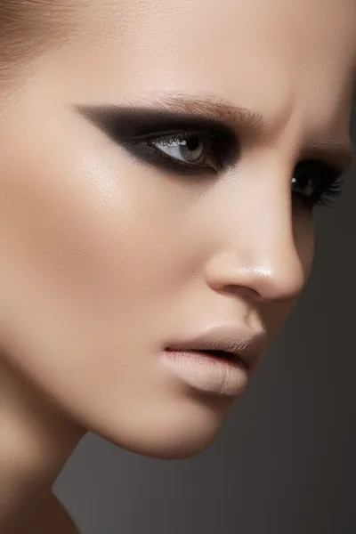 Close-up πορτρέτο ομορφιά του μοντέλου όμορφη σέξι γυναίκα με σκοτεινό βράδυ πασαρέλα μόδας μακιγιάζ στα μάτια και τα χλωμές χείλια σε γκρι φόντο — Φωτογραφία Αρχείου