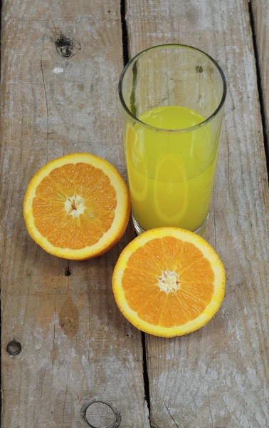 Свежий апельсиновый сок и две половины фруктов — стоковое фото