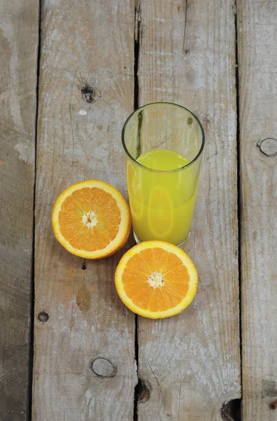 Свежий апельсиновый сок и две половины фруктов — стоковое фото