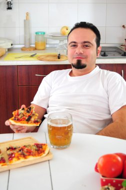 ev yapımı pizza ile mutfakta genç adam