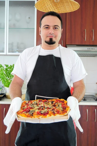 Jovem na cozinha com pizza caseira — Fotografia de Stock