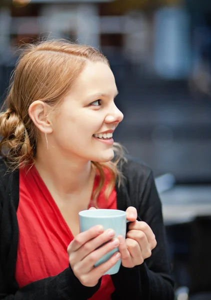 Усміхнена молода жінка з чашкою чокомолока — стокове фото