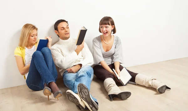 Three amused friends with books — Stock Photo, Image