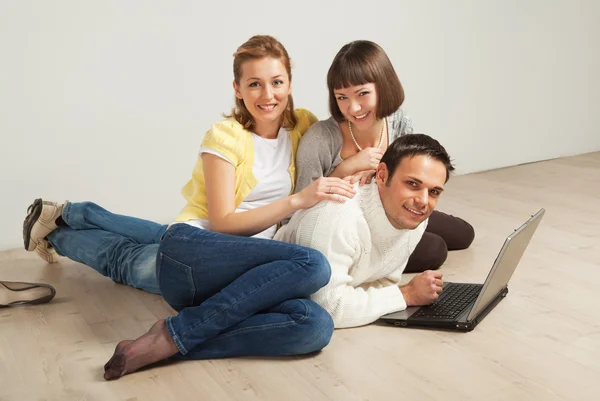 Happy friends with laptop computer — Stock Photo, Image