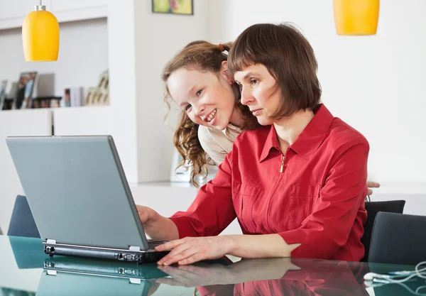Mãe e filha em casa com laptop — Fotografia de Stock