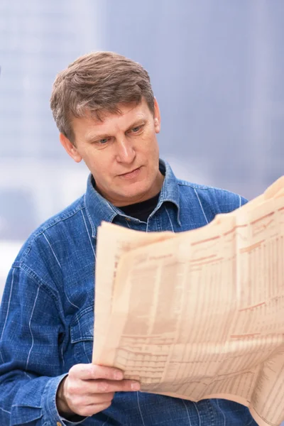 Reifer Mann liest Zeitung Stockbild