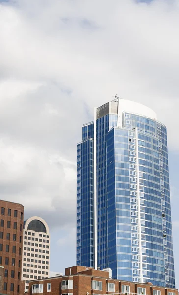 stock image Blue Glass Tower Rising from Older Buildings