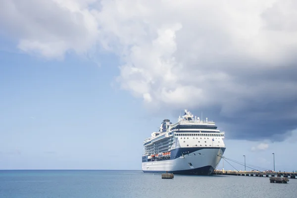Crucero azul y blanco atracado bajo nube de tormenta — Foto de Stock