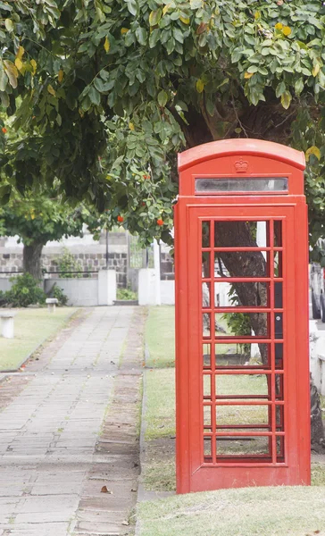 Красная телефонная будка в парке — стоковое фото