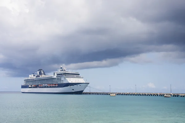 Modrá a bílá výletní loď na zelené vodě pod mraky — Stock fotografie