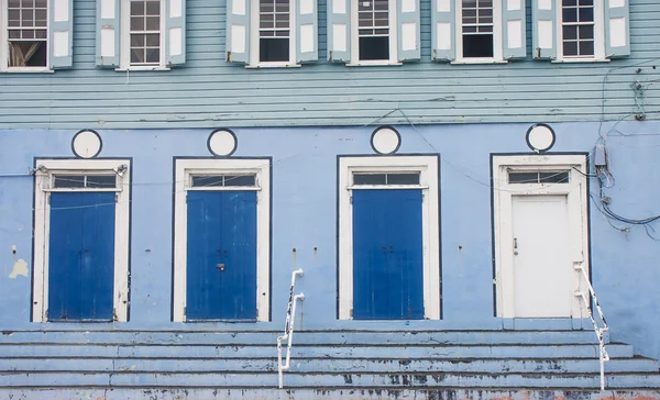 Три синие двери и одна белая — стоковое фото