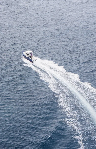 Резка синий и белый лодке через залив — стоковое фото