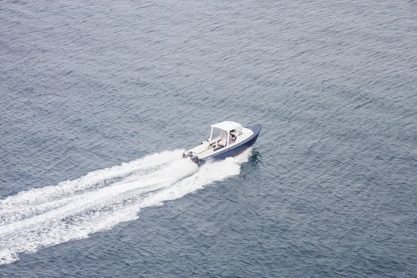 Biały i niebieski łódź szumiące całej wody — Zdjęcie stockowe