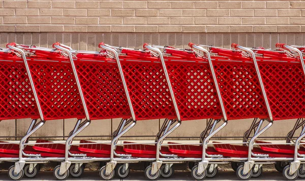 stock image Line of Red Shopping Carts by Brick Wall