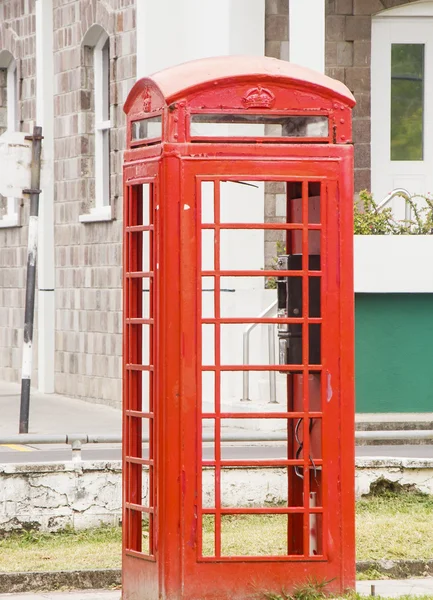 Cabina de teléfono rojo por viejo edificio de piedra — Foto de Stock