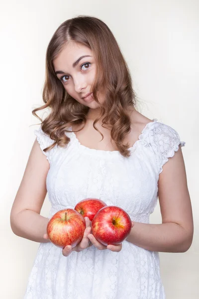 Девушка с тремя яблоками в руках — стоковое фото