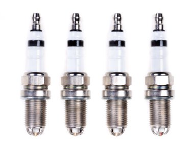 Four spark plugs. Isolated on white. clipart