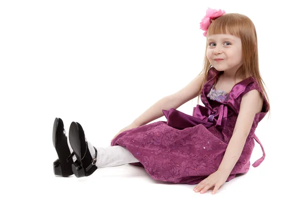 Четырехлетняя девочка сидит на белом полу — стоковое фото