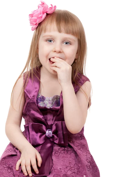 Het kleine meisje eet een snoep. geïsoleerd op een witte achtergrond — Stockfoto