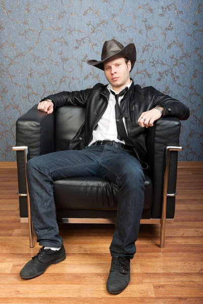 A stylish man sitting in leather chair in Interiors — Stock Photo, Image