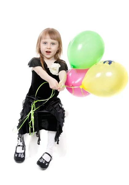 Pequena menina bonita com balões no estúdio em um bac branco — Fotografia de Stock