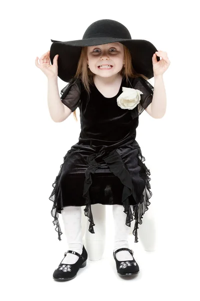 Den lilla flickan hamming i en svart filt hatt — Stockfoto