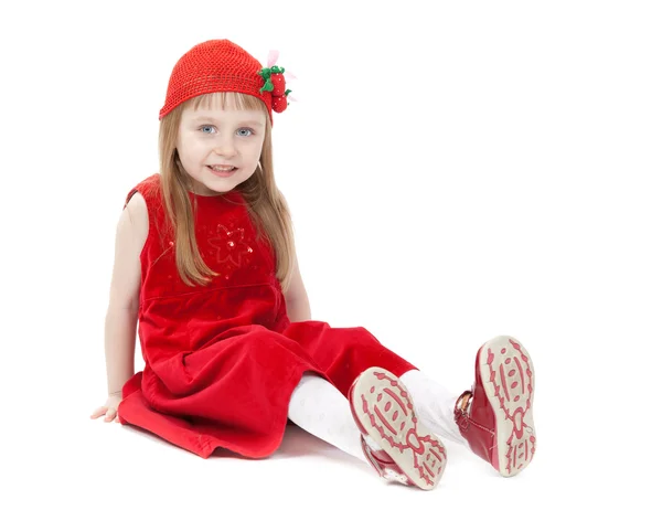 Девушка в возрасте четырех лет в красном платье, сидящая на полу — стоковое фото