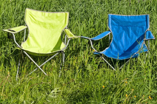 Twee lege opvouwbare stoel op het groene gras — Stockfoto