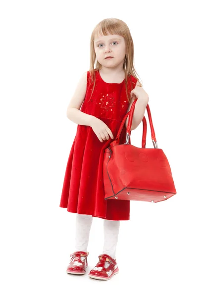 Модна маленька дівчинка з червоною сумкою, в подіумі моделі позу — стокове фото