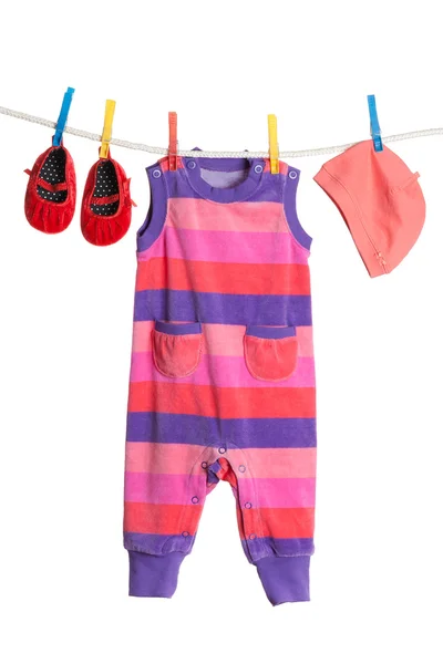 Um conjunto de roupas infantis penduradas em um varal . — Fotografia de Stock