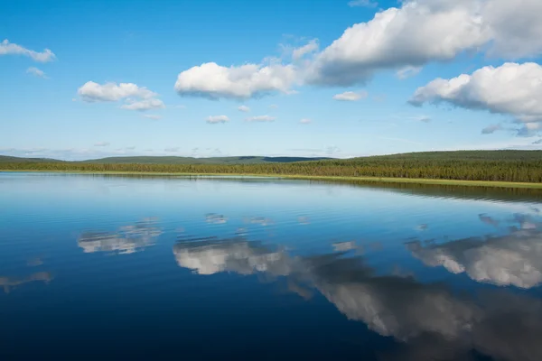 Calma hermoso paisaje rural con un lago y el cielo reflejado — Foto de Stock