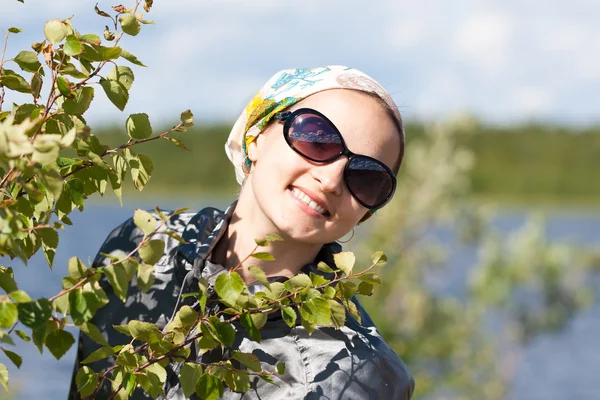 Retrato de uma menina loira atrás do arbusto verde — Fotografia de Stock