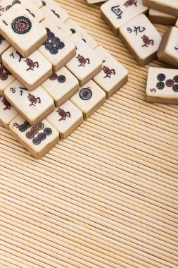 Old chinese game mahjongg on bamboo mat background clipart