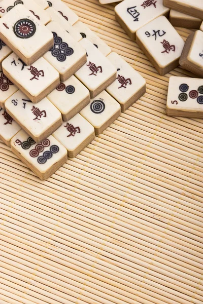 Antiguo juego chino mahjongg sobre fondo estera de bambú — Foto de Stock
