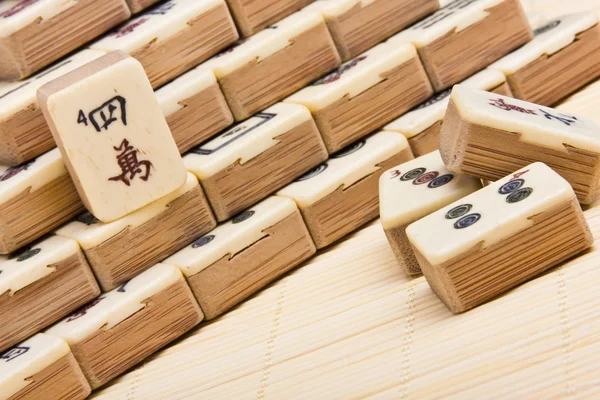 Antiguo juego chino mahjongg sobre fondo estera de bambú Fotos de stock