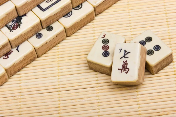 Vecchio gioco cinese mahjongg su sfondo tappetino di bambù Foto Stock Royalty Free
