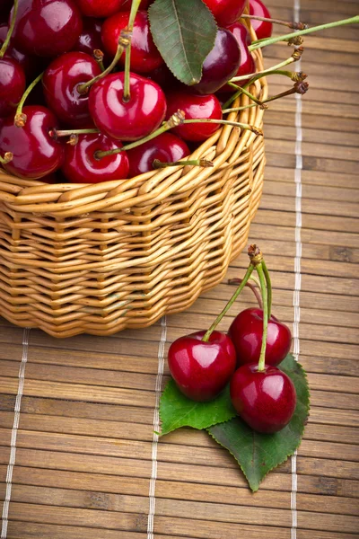 Delicious sweet cherry fruits in wicker basket — Stock Photo, Image