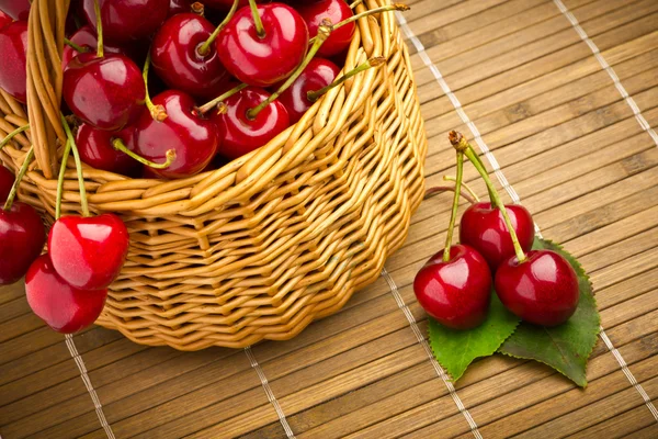 Вкусные сладкие вишневые фрукты в плетеной корзине — стоковое фото