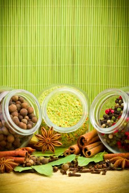 Pack of several spices and herbs in glass jars clipart