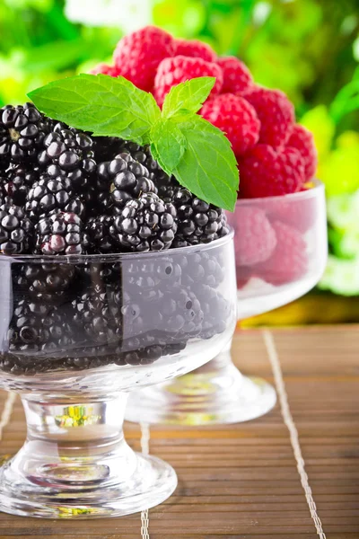 Süße frische Früchte im Glaskelch mit Minzblatt — Stockfoto