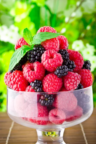 Dulces frutas frescas en copa de vidrio con hoja de menta —  Fotos de Stock