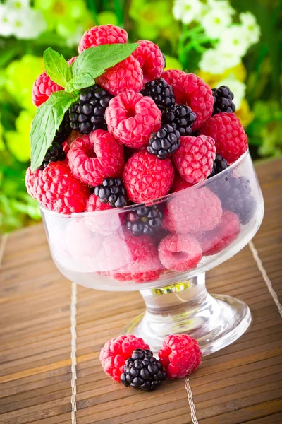 Frutta fresca dolce in calice di vetro con foglia di menta — Foto Stock