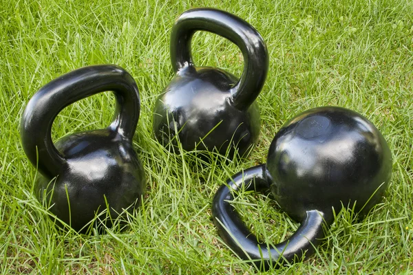 Sinos de kettlebell pesados na grama — Fotografia de Stock