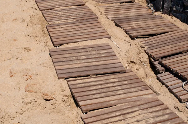 Omšelé dřevěné promenádě na písku — Stock fotografie