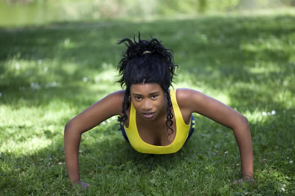 Młody african american kobieta robi pompki na zewnątrz — Zdjęcie stockowe