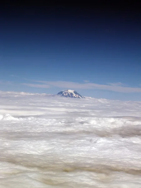 Één bergtop temidden van laag van wolken — Stockfoto