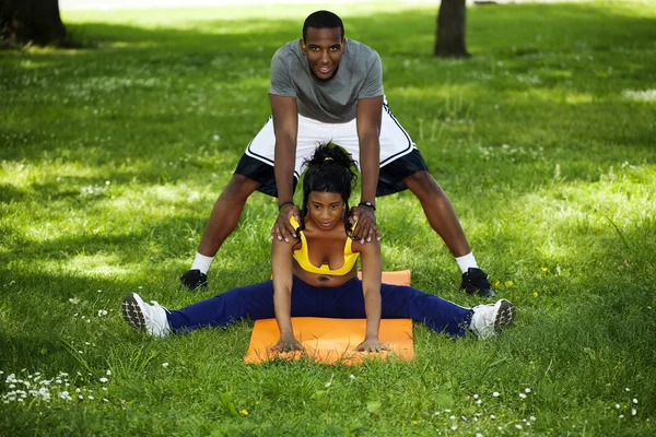 Чернокожий мужчина и чернокожая женщина занимаются в парке — стоковое фото