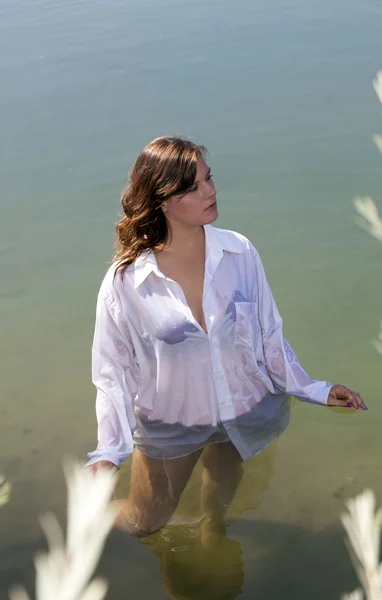 Молода жінка, стоячи в річки біла сорочка — стокове фото