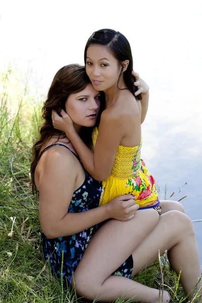 Duas jovens mulheres abraçando ao ar livre vestidos rio — Fotografia de Stock