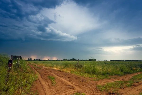 Strada rurale e nuvole buie tempesta — Foto Stock